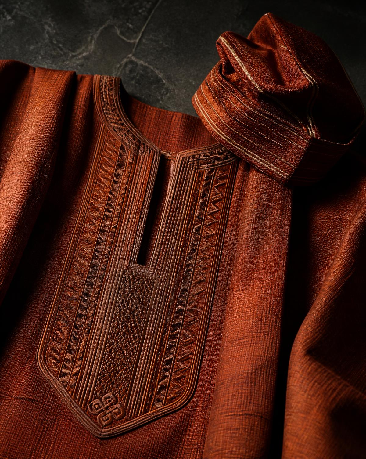 Rust aso-oke embroidery and a matching fila photographed on dark stone