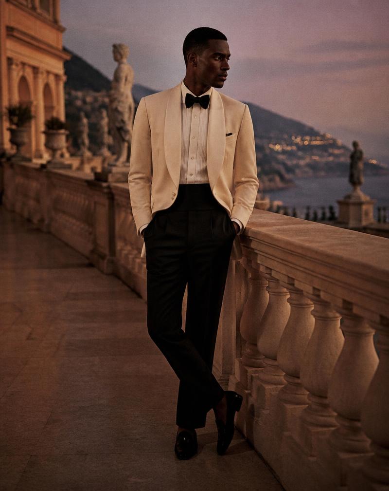 An ivory dinner jacket with black evening trousers photographed on a terrace at dusk